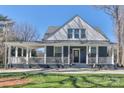 Charming blue two-story home featuring a welcoming porch and a well-manicured front lawn at 704 N Main Ave, Newton, NC 28658