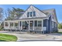 Beautiful blue house with a classic white porch, complemented by lush greenery and a welcoming entrance at 704 N Main Ave, Newton, NC 28658