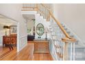 Elegant foyer featuring a staircase with white railings, hardwood floors, and a decorative mirror at 727 Mayfield Ct, Fort Mill, SC 29715