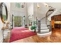 Welcoming foyer with a curved staircase, arched doorway, and views of the outdoor landscape at 7509 Webbs Chapel Cove Ct, Denver, NC 28037