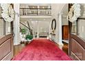 Grand foyer with soaring ceilings, open balcony, hardwood floors, and natural light at 7509 Webbs Chapel Cove Ct, Denver, NC 28037