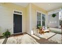Inviting front porch features a comfortable seating area, potted plants, and a hanging fern for a cozy feel at 7807 Chaddsley Dr, Huntersville, NC 28078