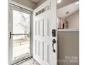 View of the entryway showcasing a white front door with glass panel, neutral walls, and glimpses of the kitchen at 810 Rock Lake Gln, Fort Mill, SC 29715
