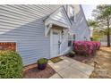 Inviting front entrance with a white door, stylish awning, and vibrant landscaping with blooming azalea bushes at 810 Rock Lake Gln, Fort Mill, SC 29715