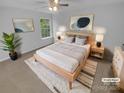 A staged bedroom featuring neutral tones, a ceiling fan, a window with a natural outdoor view and modern decorations at 9037 Pembroke Ct, Fort Mill, SC 29707