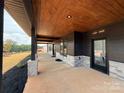 Beautiful porch featuring wood ceiling, stone accents, and dark modern trim and black door frames at 108 Winners Cir # 5, Mooresville, NC 28117
