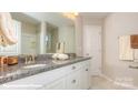 Bright bathroom with a double sink vanity, granite countertop, and ample storage space at 116 Asmodean Ln, Troutman, NC 28166