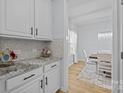 Bright kitchen with white cabinets, granite countertop, a mosaic backsplash, and eat-in breakfast area at 1205 Brooksland Pl, Waxhaw, NC 28173