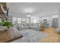 Inviting living space with hardwood floors, modern lighting, comfortable seating, and an open-concept kitchen at 1205 Brooksland Pl, Waxhaw, NC 28173