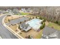 Aerial view of a community pool, pool house, parking, manicured landscaping, and surrounding neighborhood homes at 1205 Brooksland Pl, Waxhaw, NC 28173