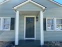 Inviting home entrance featuring a stylish front door, decorative lantern, and windows with dark shutters at 1239 Mitchell Ave, Statesville, NC 28677