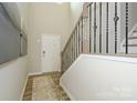 Inviting entryway with hardwood floors, staircase with decorative wrought iron railing, and neutral paint at 15311 Lake Ridge Rd, Charlotte, NC 28278