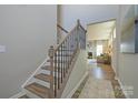 Staircase with decorative wrought iron railing transitioning to open-concept living space at 15311 Lake Ridge Rd, Charlotte, NC 28278