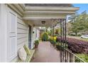 Side angle of covered front porch featuring a bench with throw pillows and black metal railing at 1644 Morningside Dr, Charlotte, NC 28205
