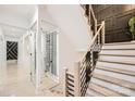 Bright, open staircase features wooden steps, black metal railings, and a glass-enclosed wine storage area at 16744 Ashton Oaks Dr, Charlotte, NC 28278