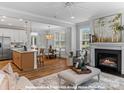 Open-concept living space with a fireplace, seamlessly connected to a modern kitchen and dining area at 19728-B School St, Cornelius, NC 28031