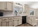 Well-lit kitchen featuring custom backsplash, granite countertops, black appliances, and wood-look flooring at 205 King David Ln, Gastonia, NC 28056