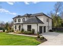 Beautiful white brick home featuring manicured lawn, professional landscaping, and a wide driveway at 300 Mammoth Oaks Dr, Charlotte, NC 28270