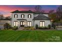 Charming white brick home featuring a manicured lawn, striking black shutters and a welcoming entranceway at 300 Mammoth Oaks Dr, Charlotte, NC 28270