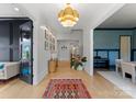 Bright foyer featuring a hardwood floor, modern light fixture, and an open floor plan at 300 Mammoth Oaks Dr, Charlotte, NC 28270