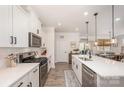 Modern kitchen featuring sleek countertops, stainless steel appliances, and an adjacent dining area with natural light at 7056 Cornwallis Ct, Iron Station, NC 28080