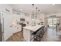 Bright, modern kitchen with white cabinets, stainless steel appliances, a large island, and bar stool seating at 7056 Cornwallis Ct, Iron Station, NC 28080