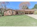 Charming brick ranch home with a long driveway and covered carport nestled on a lush, green lawn at 737 Waverly Pl, Statesville, NC 28677