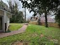 Relaxing backyard with beautiful landscaping and a brick path leading to a fire pit at 842 E Woodlawn Rd, Charlotte, NC 28209