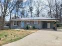 Inviting front exterior features a freshly painted gray brick, light blue door, and convenient covered carport at 112 Greentree Dr, Mount Holly, NC 28120