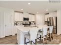 The spacious kitchen features white cabinets, stainless steel appliances, and a large center island with bar seating at 13337 Hampton Bay Ln, Charlotte, NC 28262