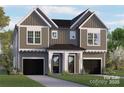 Charming two-story home featuring vertical siding, black door, two-car garages and well-manicured landscaping at 1411 Downs Ave, Charlotte, NC 28205