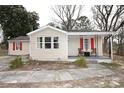 Quaint home with neutral vinyl siding, bright red shutters and a cozy, covered front porch at 2010 Simmons St, Gaston, NC 28052