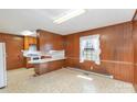 View of the kitchen with wood paneling and a breakfast bar at 219 Summit St, Norwood, NC 28128