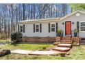 A well-maintained single-story home with a brick foundation, striking red door, and tidy landscaping at 230 Valley View Dr, Clover, SC 29710