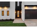 Modern home entrance featuring sleek black framed glass door and manicured lawn at 2924 Springs Dr, Charlotte, NC 28226