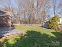 Large backyard with a spacious deck and a storage shed, surrounded by a wooden fence at 3274 Roberta Farms Sw Ct, Concord, NC 28027