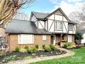 Charming two-story Tudor-style home with a brick facade, dark trim, and manicured landscaping at 5217 Camilla Dr, Charlotte, NC 28226