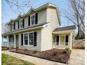 Charming two-story home featuring a welcoming side porch with landscaped garden at 7025 Spring Morning Ln, Charlotte, NC 28227