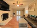 Bright living room featuring hardwood floors, a brick fireplace, and access to the backyard at 7025 Spring Morning Ln, Charlotte, NC 28227