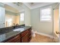 Bathroom featuring granite countertop, wooden cabinets, and ceramic tile flooring at 82 Paddington Sw Dr, Concord, NC 28025