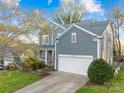 Charming blue home with an attached garage, well-maintained lawn, and a classic American aesthetic at 10105 Bon Meade Ln, Cornelius, NC 28031