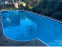 In-ground swimming pool with lounge chair and mature landscaping at 10105 Bon Meade Ln, Cornelius, NC 28031