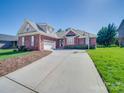 Charming brick home with a two-car garage, a long driveway, and a well-maintained lawn at 108 Avaclaire Way, Indian Trail, NC 28079