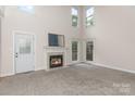 Bright living room with fireplace, neutral carpet, high ceilings, and abundant natural light at 1120 Millwright Ln, Matthews, NC 28104