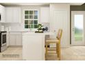 Modern kitchen features white cabinetry, an island with seating, and stainless steel appliances at 1192 Blackburn Cir, Edgemoor, SC 29712