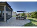Relax and unwind on this paver patio featuring ample space for outdoor dining underneath a large umbrella at 14229 Twin Eagles Ln, Charlotte, NC 28278