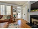 Cozy living room with a fireplace, hardwood floors, and a view of the front door at 151 E Morehouse Ave, Mooresville, NC 28117