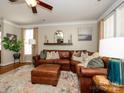 Spacious living room with a comfortable leather sectional, a ceiling fan, and lots of natural light at 151 E Morehouse Ave, Mooresville, NC 28117