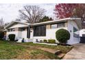 Charming home featuring a brick and white facade with a well-manicured lawn and mature trees at 1621 Keeling Pl, Charlotte, NC 28210