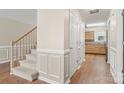 Bright hallway with wood floors leads to a staircase and the kitchen, enhancing the home's inviting atmosphere at 176 Columns Cir, Shelby, NC 28150